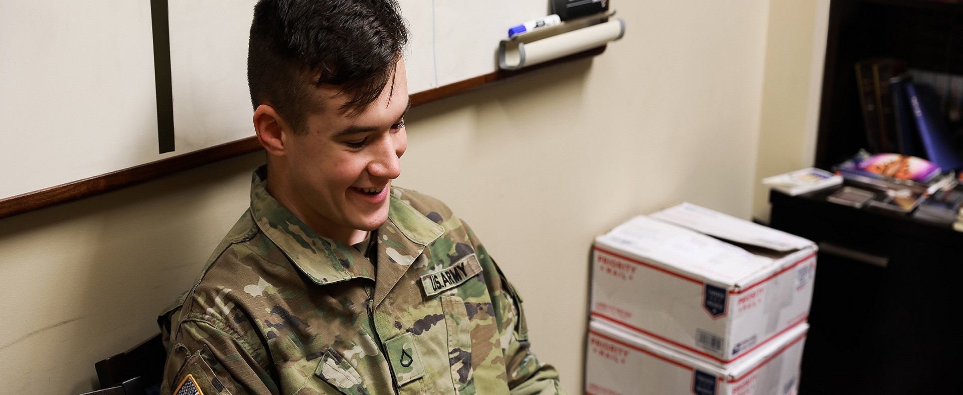 Pfc. Christopher Mullenix, religious affairs specialist, 123rd Brigade Support Battalion, 3rd Armored Brigade Combat Team, 1st Armored Division (Rotational), smiles as he reads a holiday Christmas card sent from an eighth-grade student at Mesa Verde Middle School, San Diego, California. (U.S. Army photo by Sgt. Alon J. Humphrey, 3rd ABCT, 1st AD Public Affairs)